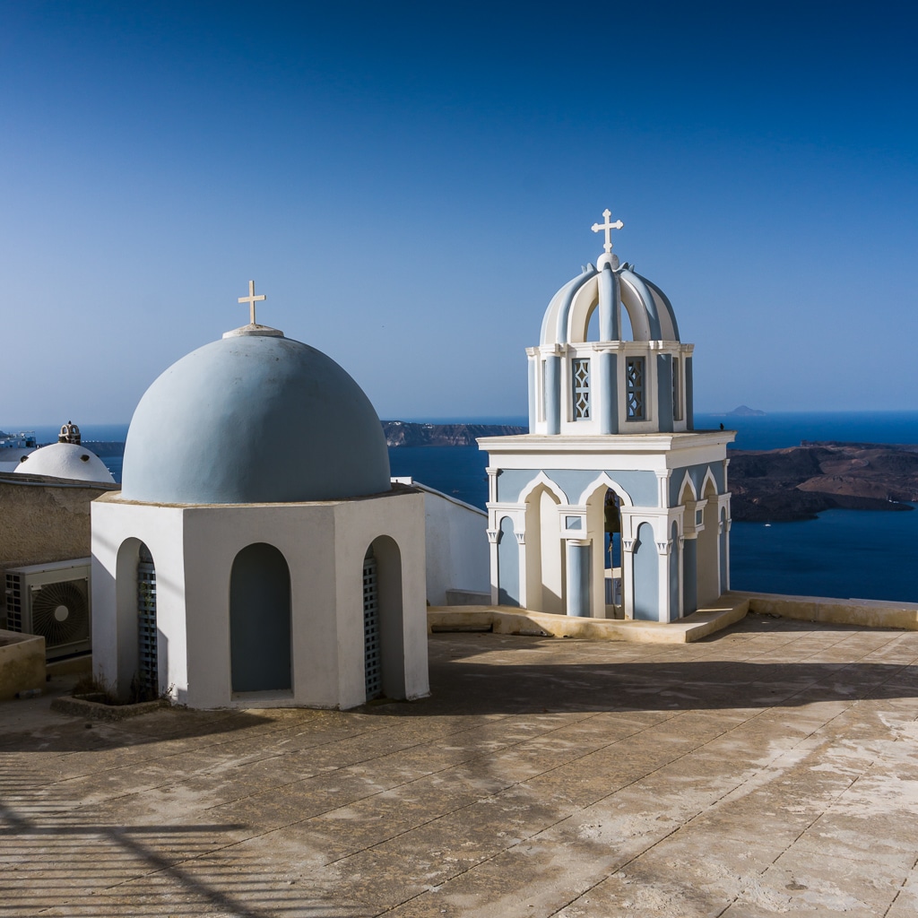 Photographie d une eglise et d un dome bleu a Fira sur l ile de Santorin