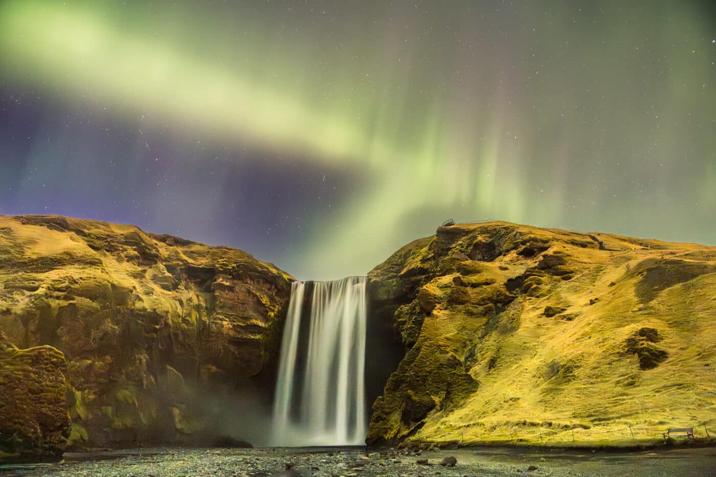 Aurores boréales au-dessus de la cascade Skógafoss pendant un stopover en Islande